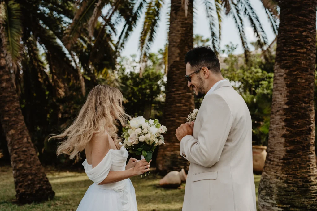 Newly married couple walking beneath palm trees in Mallorca