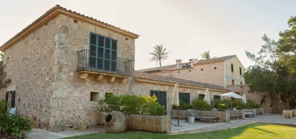 Traditional stone building in Mallorca with green shutters, terraces and a garden