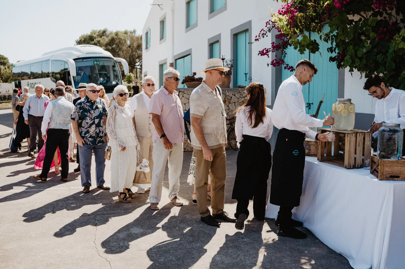 Wedding guests arriving by coach and being welcomed with refreshments at a Mallorca wedding